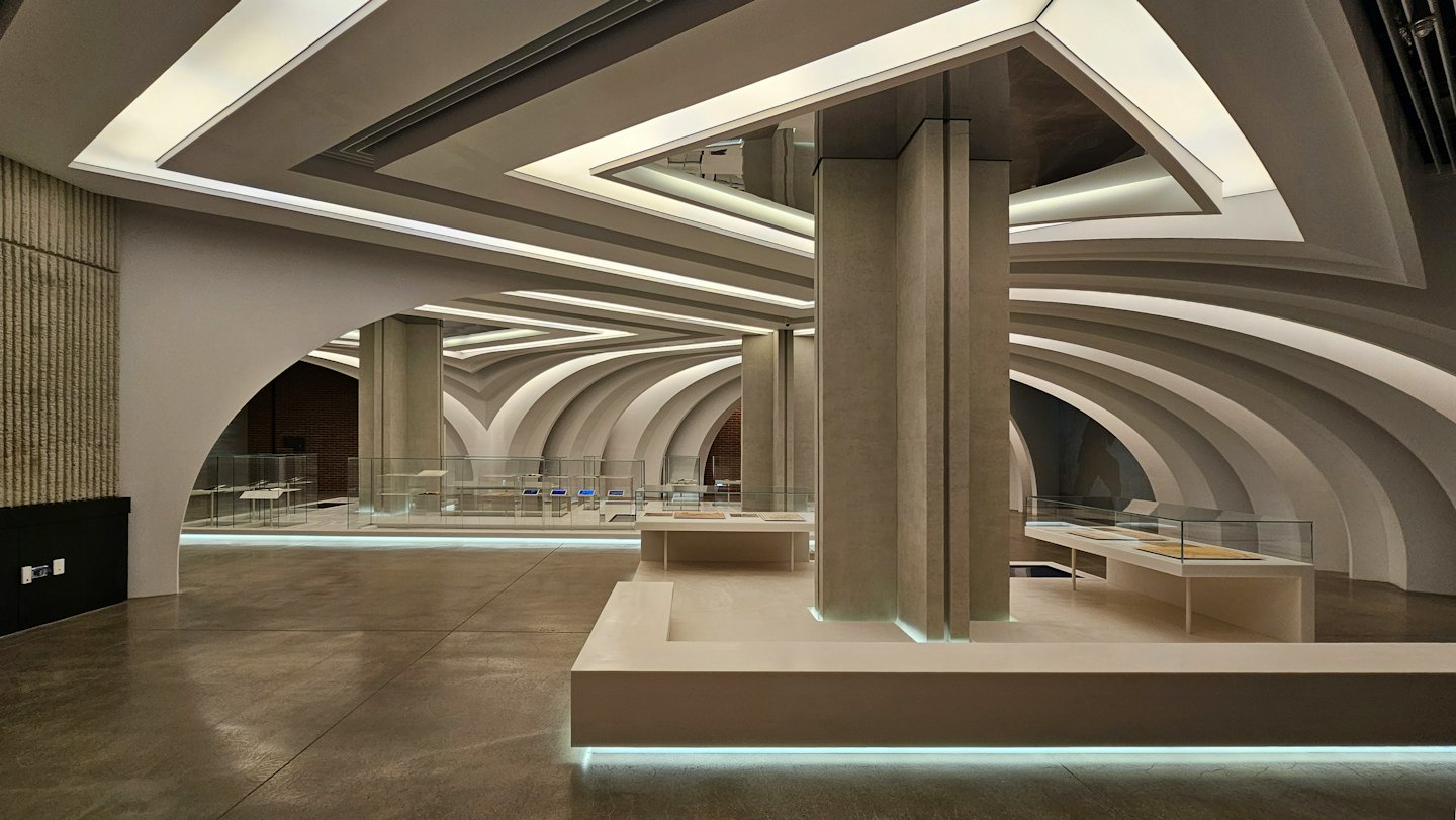 Modern architectural space with arched walls and concrete columns.